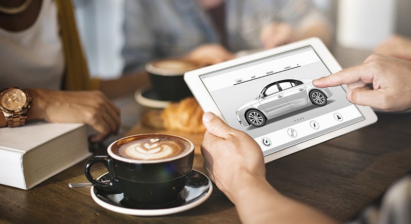 A person viewing a car on tab